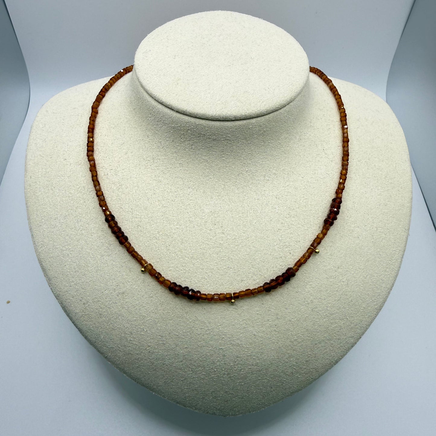 Brown beaded necklace on a white display bust