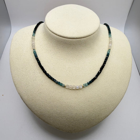 Blue beaded necklace on a white display bust.