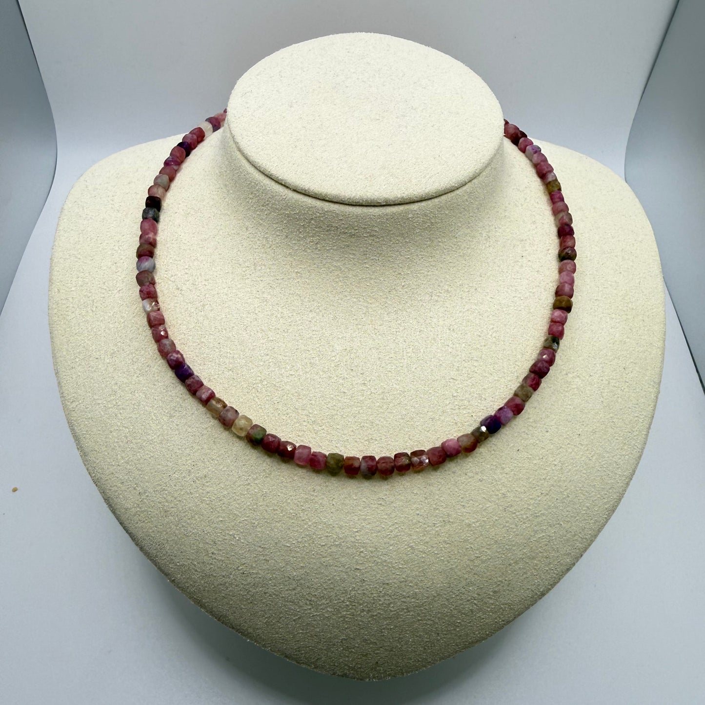 Pink beaded necklace on a white display bust
