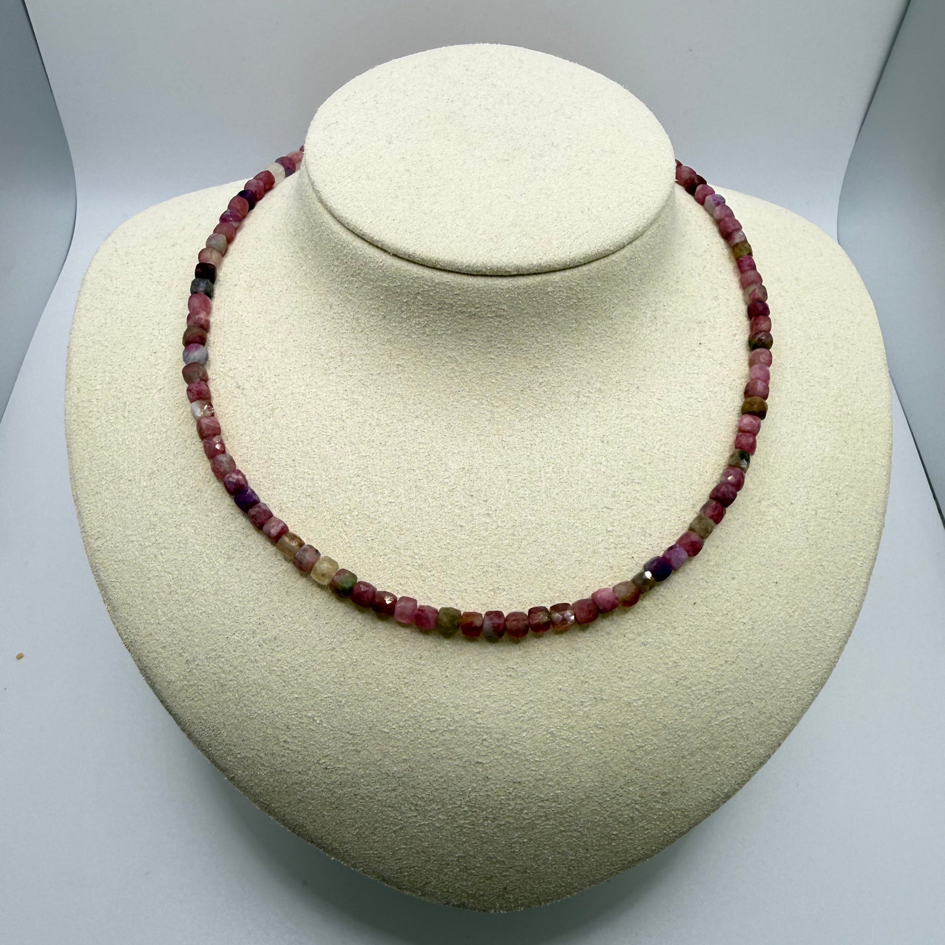 Pink beaded necklace on a white display bust