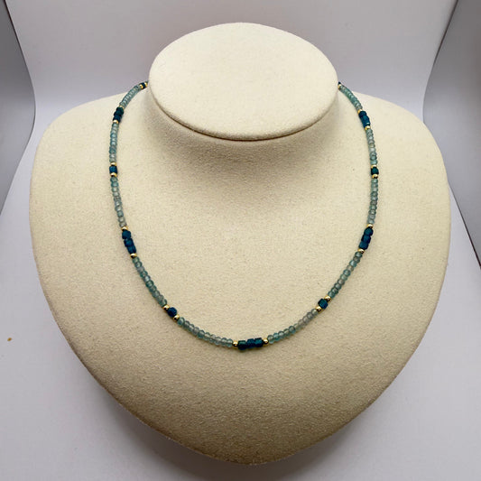 Blue beaded necklace on a white display bust.