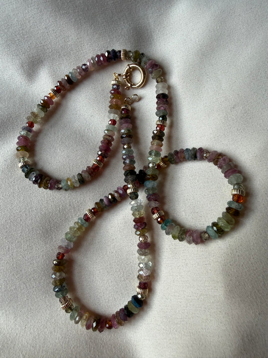 Multicolored beaded necklace and bracelet on a light fabric background