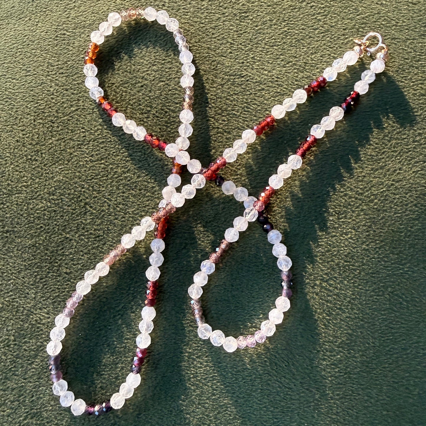 Beaded necklace on a textured green surface