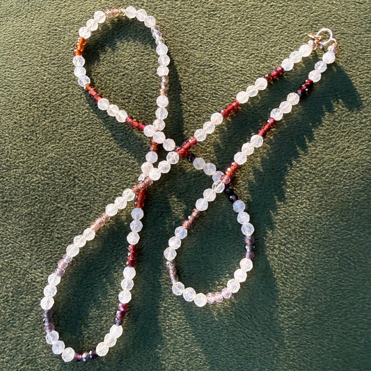 Beaded necklace on a textured green surface