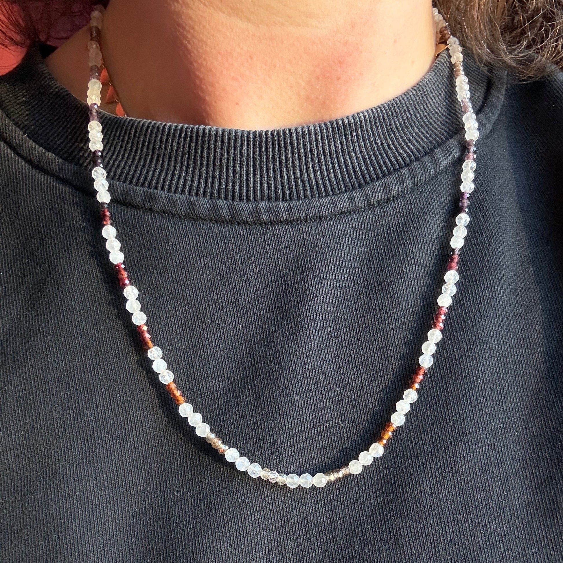 Beaded necklace on a person against a dark background